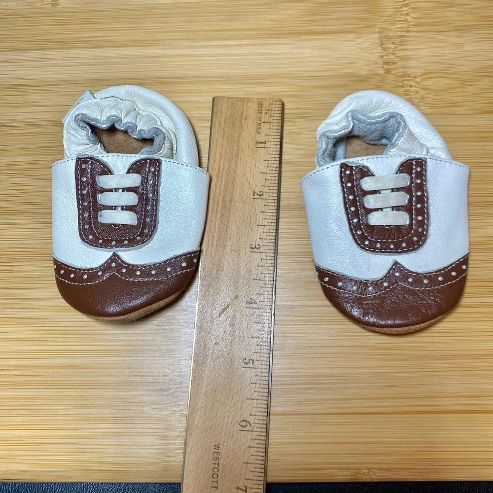 White and brown wingtip baby shoes
